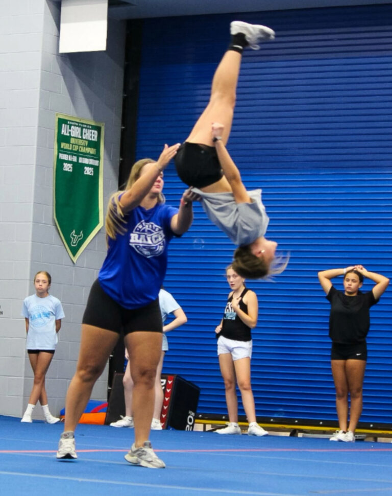 A woman performing a handstand on a gymnastics floor, showcasing strength and balance in her athletic pose.