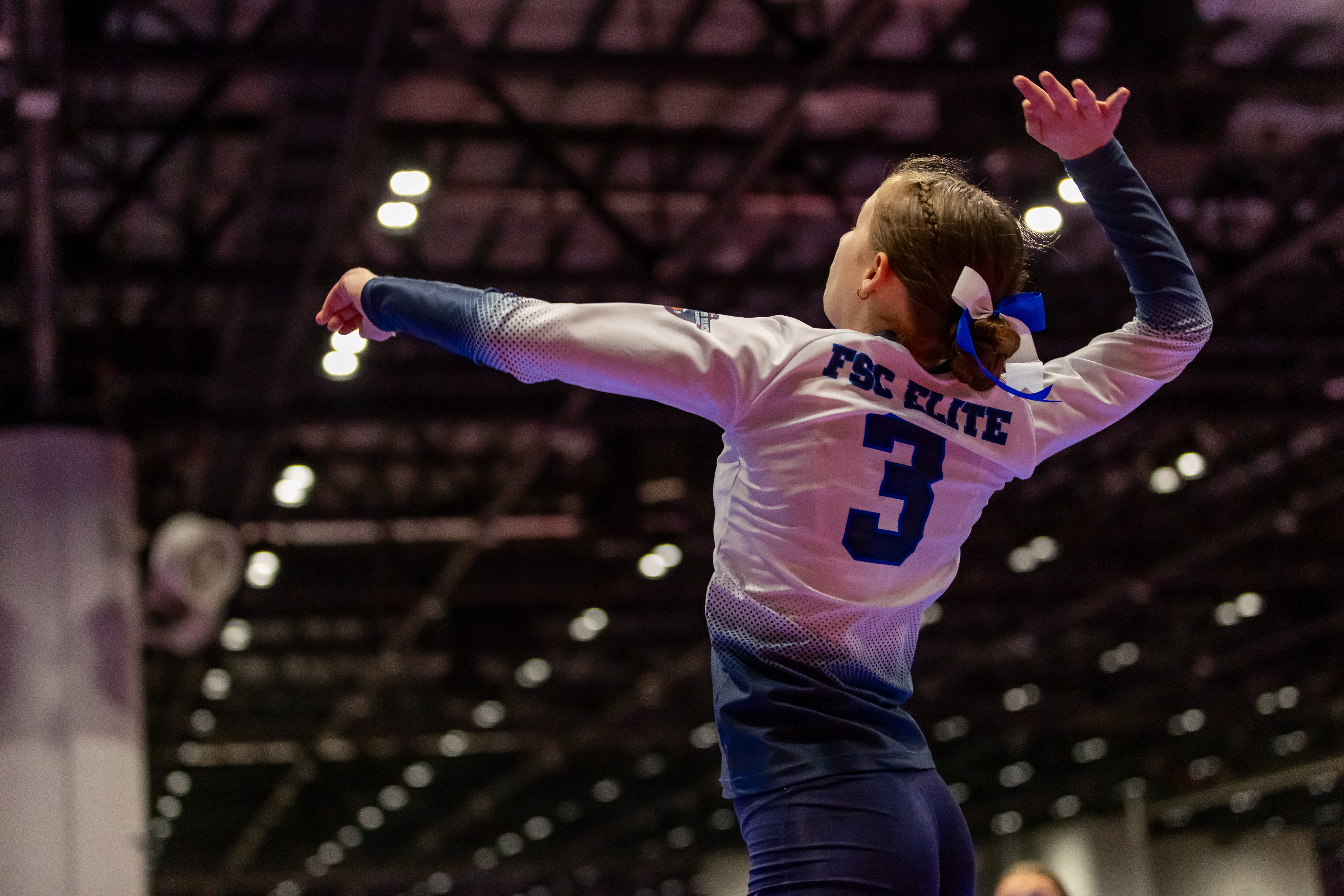A volleyball player strikes the ball with her hand during a match, showcasing her athleticism and focus.