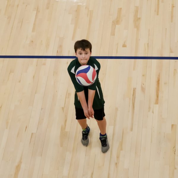 Prep and Developmental Volleyball 12 Volleyball player bump sets a ball