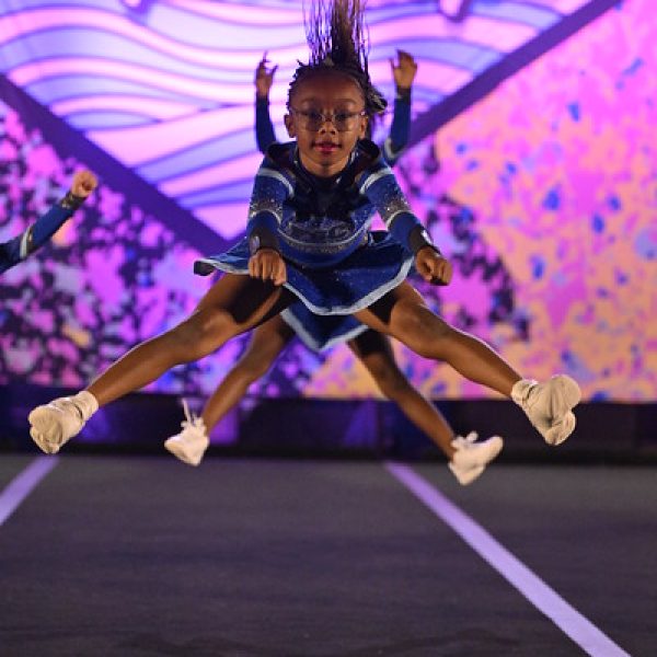Cheerleaders execute an impressive aerial stunt during a competitive cheerleading event.