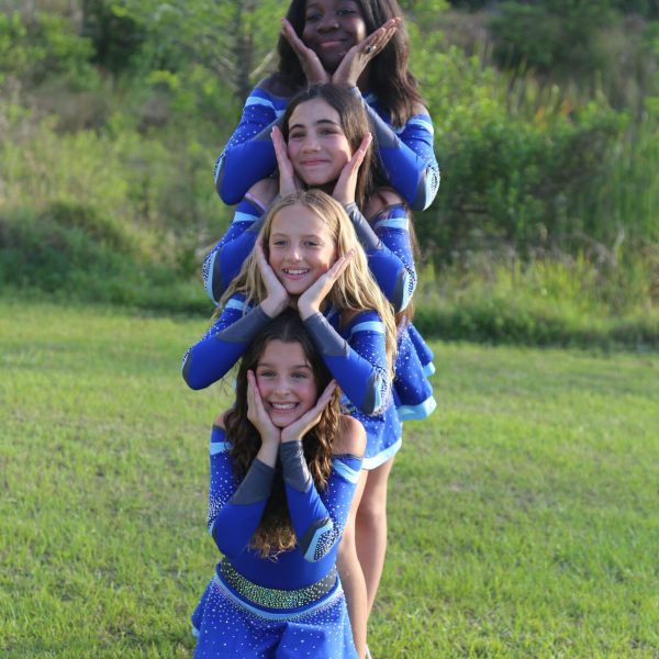 A group of cheerleaders in uniforms smiling and posing together for a team photo.