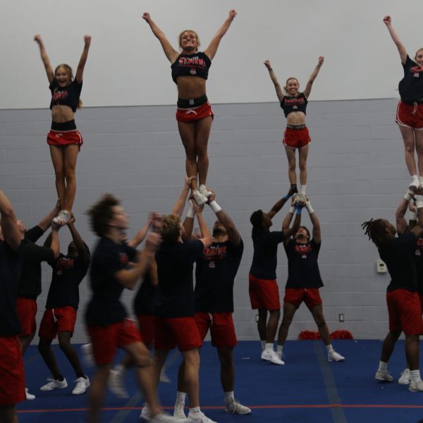 Cheerleaders execute an impressive aerial stunt during a competitive cheerleading event.