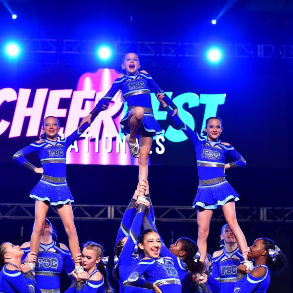 A group of cheerleaders in uniforms smiling and posing together for a team photo.